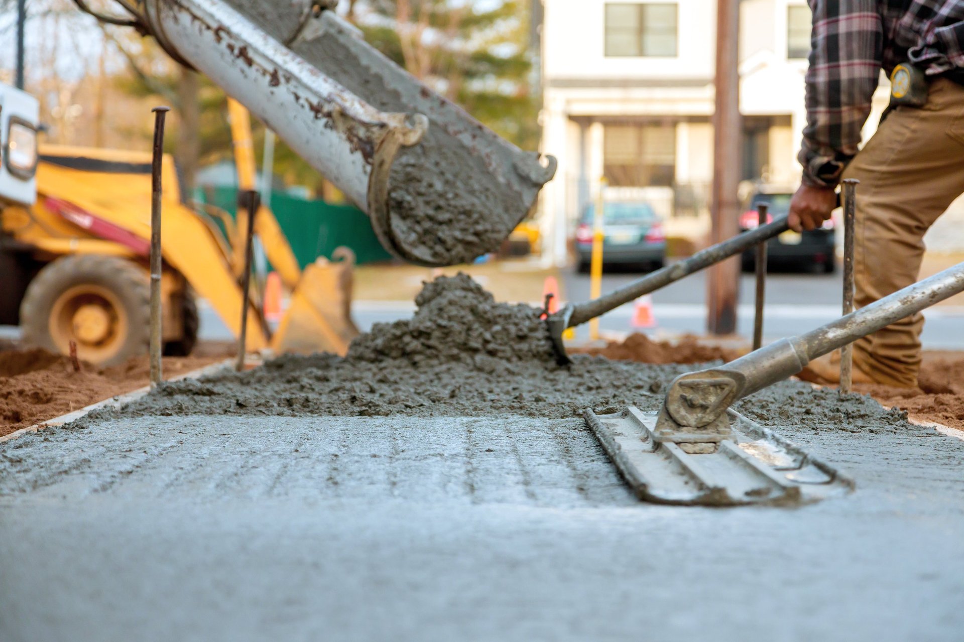 Workers pour and level fresh concrete for sidewalk
